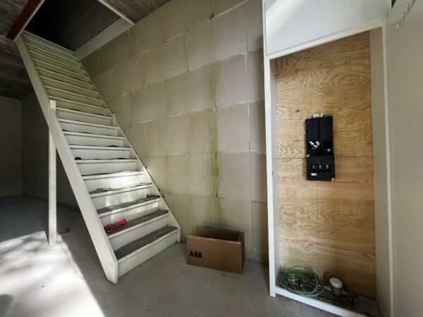 Beginnende elektrische installatie naast een witte trap in een casco nieuwbouwwoning aan de Broekdijk West.